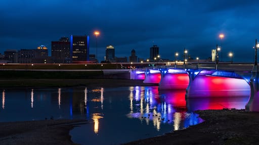 illuminated Red White and Blue 5th Street Bridge crosses Miami River at night into Dayton Ohio