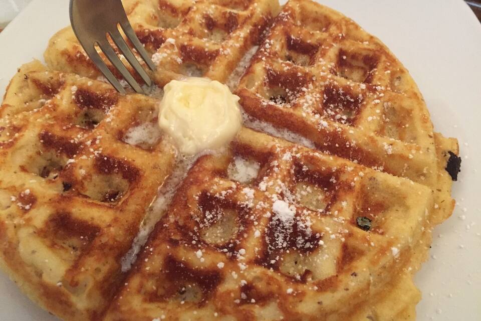Ein Teller belgische Waffeln mit Butter und Puderzucker.