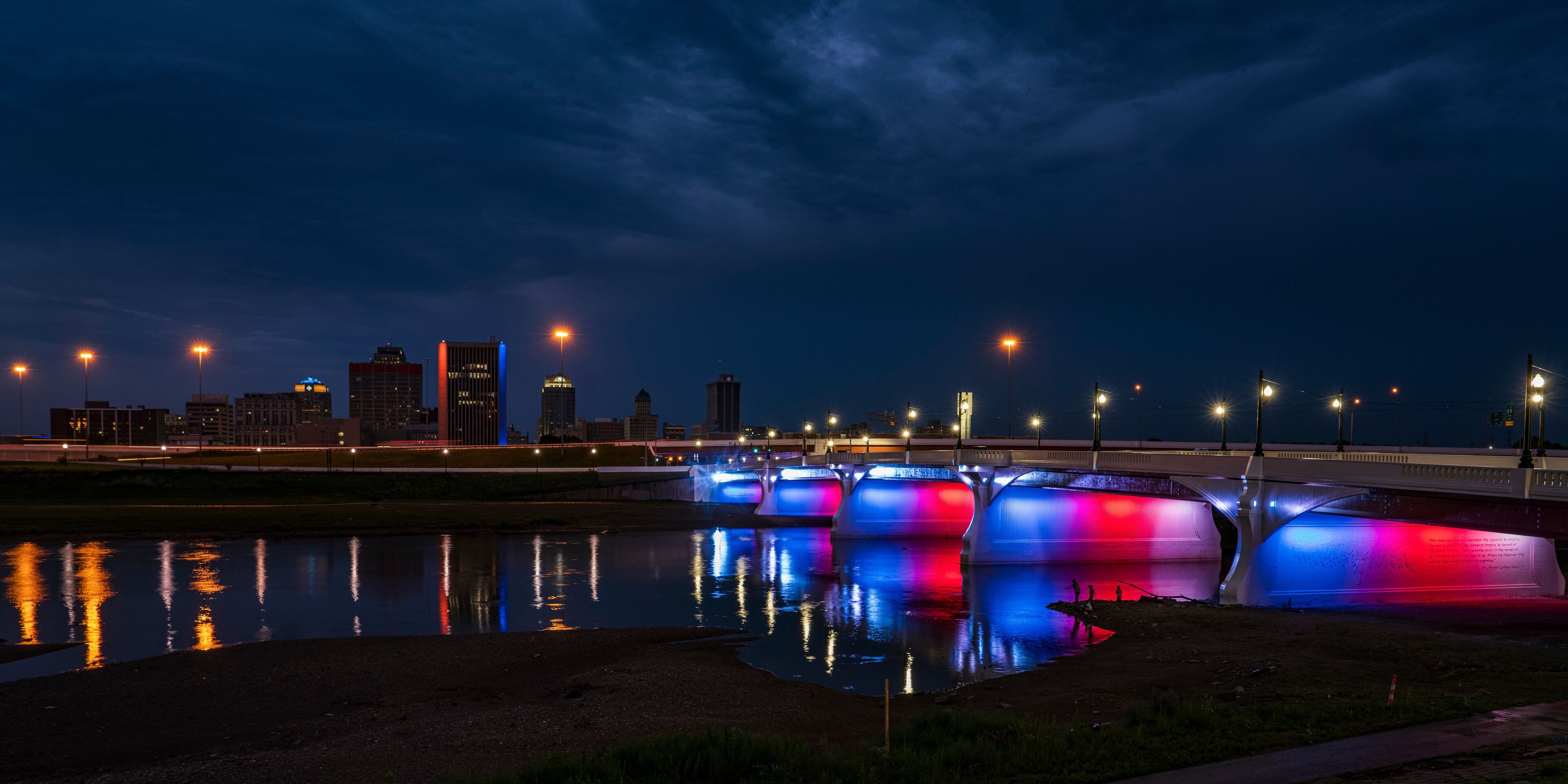 illuminated Red White and Blue 5th Street Bridge crosses Miami River at night into Dayton Ohio