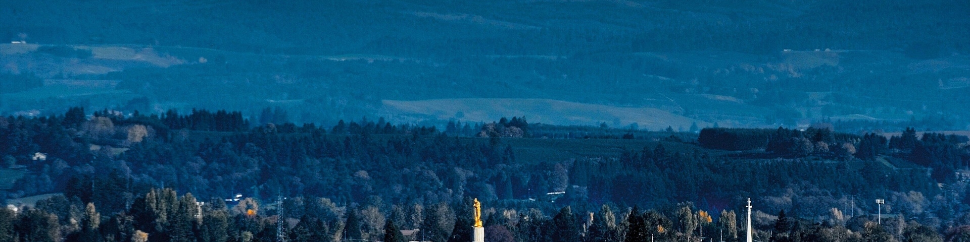 Un paisaje urbano con una montaña destacada al fondo.