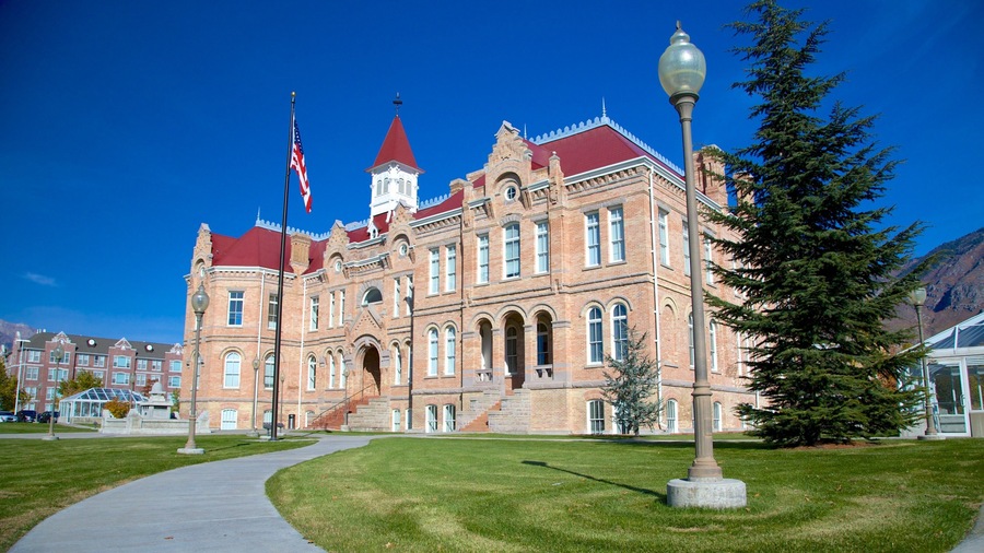 A historic brick building with a red roof and a clock tower.