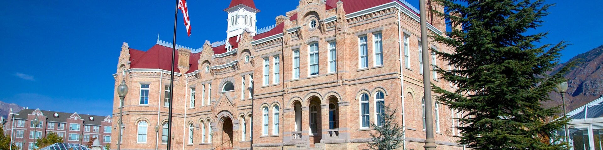 A historic brick building with a red roof and a clock tower.