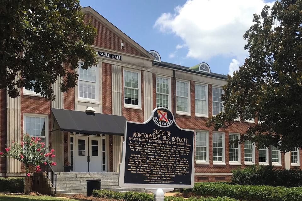A building with a sign reading "Council Hall" and another sign detailing the Montgomery Bus Boycott.