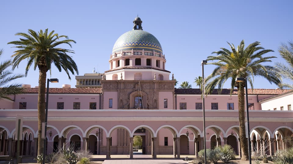A historic building with a large dome and arched walkways.