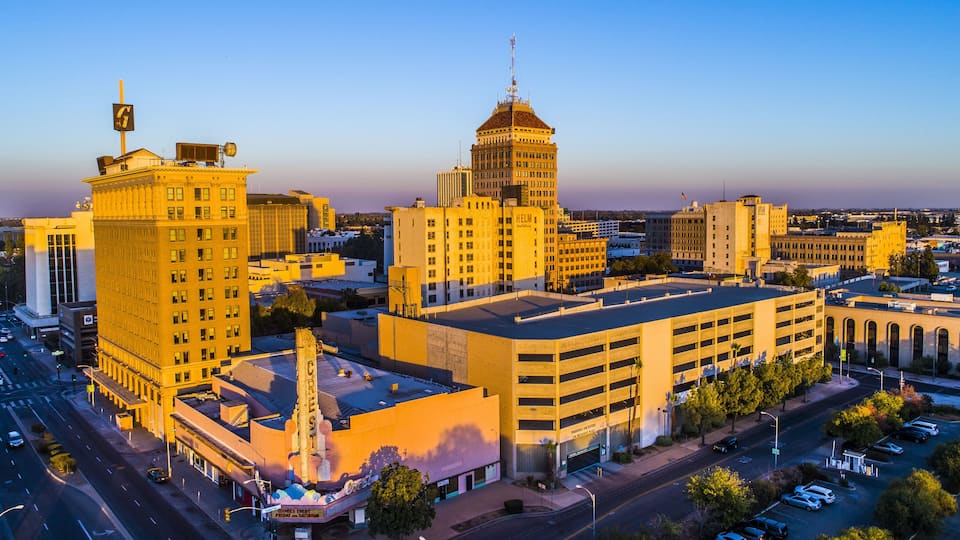 A cityscape with prominent buildings, including a large yellow building with a tower and a building with a dome.