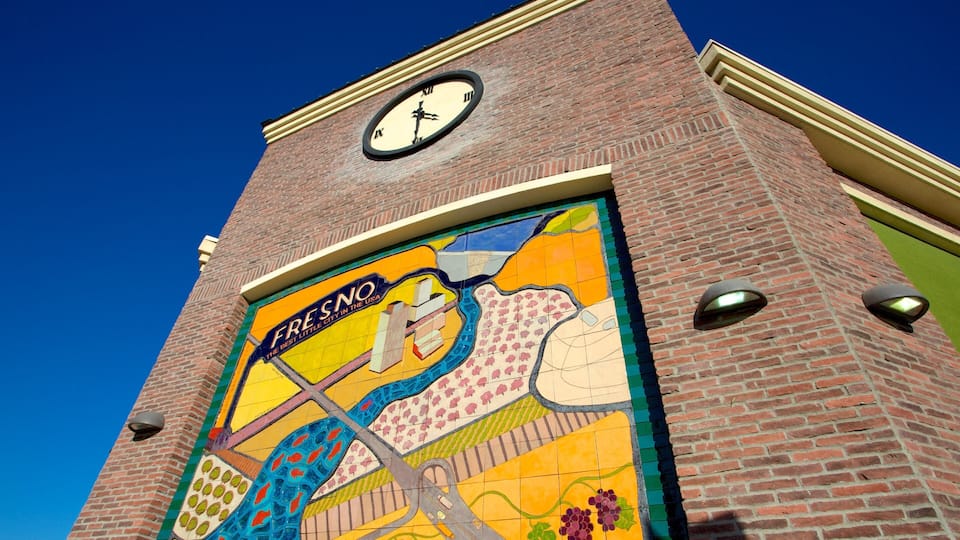A building with a clock and a colorful mural.