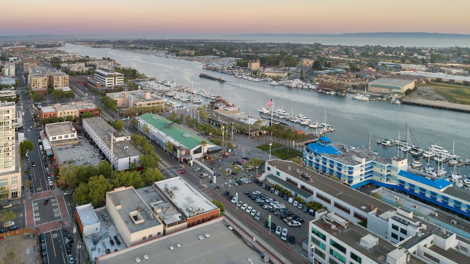 A marina with boats, a river, and surrounding buildings.