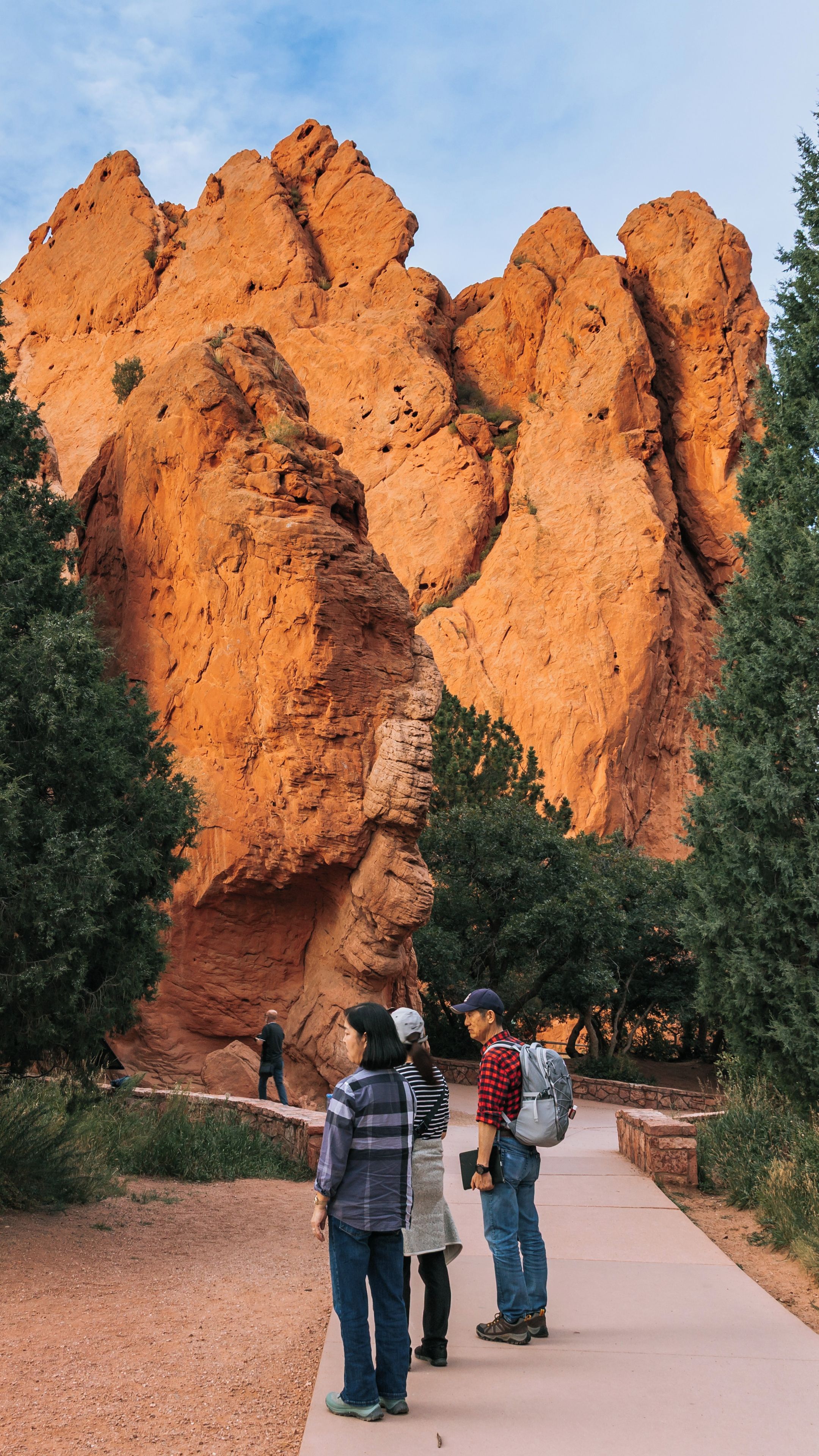 A large red rock formation with a pathway leading up to it.