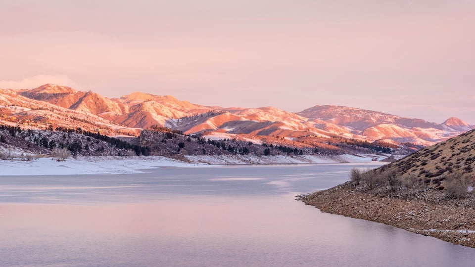 A frozen river with mountains in the background.