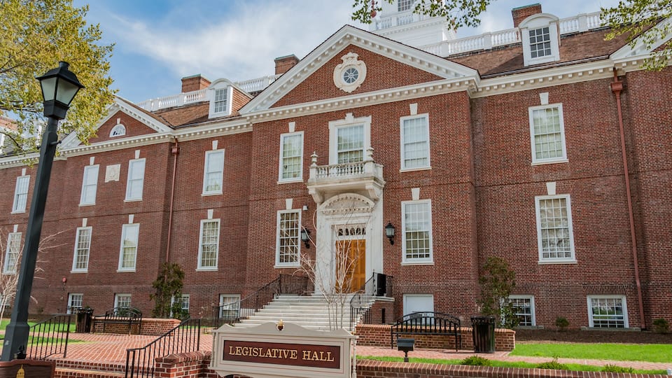A red brick building with a sign reading 'LEGISLATIVE HALL' and a staircase leading to the entrance.