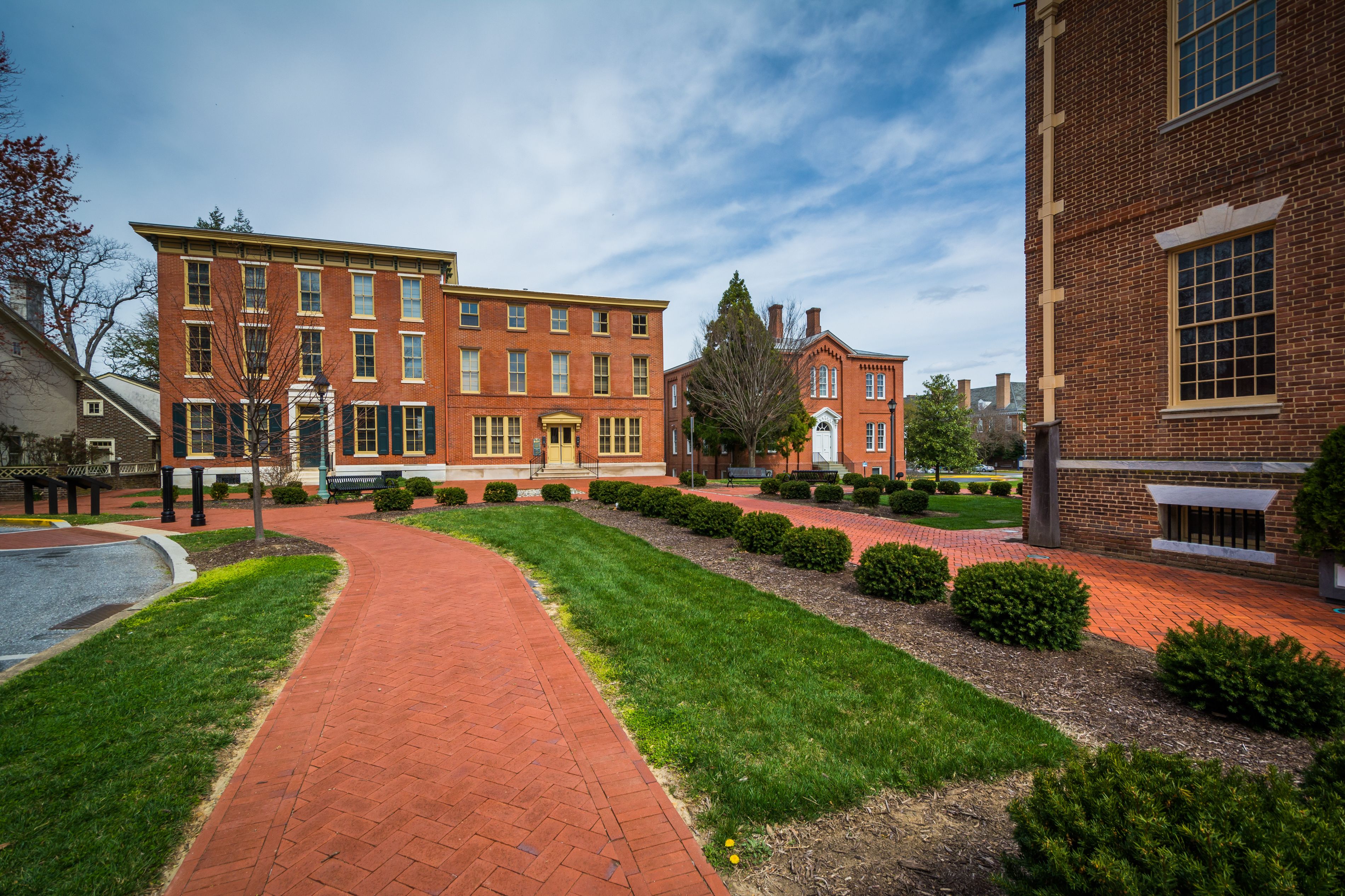 A brick building with a red brick pathway leading to it.