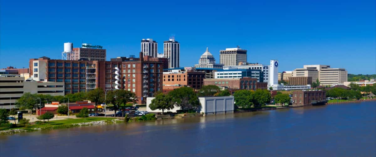 A city skyline with a river in the foreground.