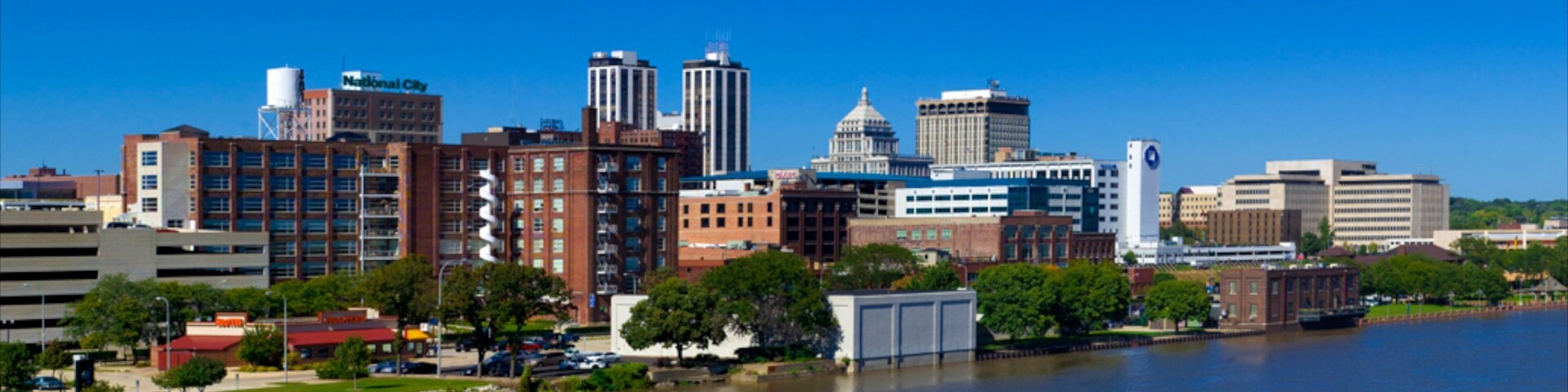 A city skyline with a river in the foreground.
