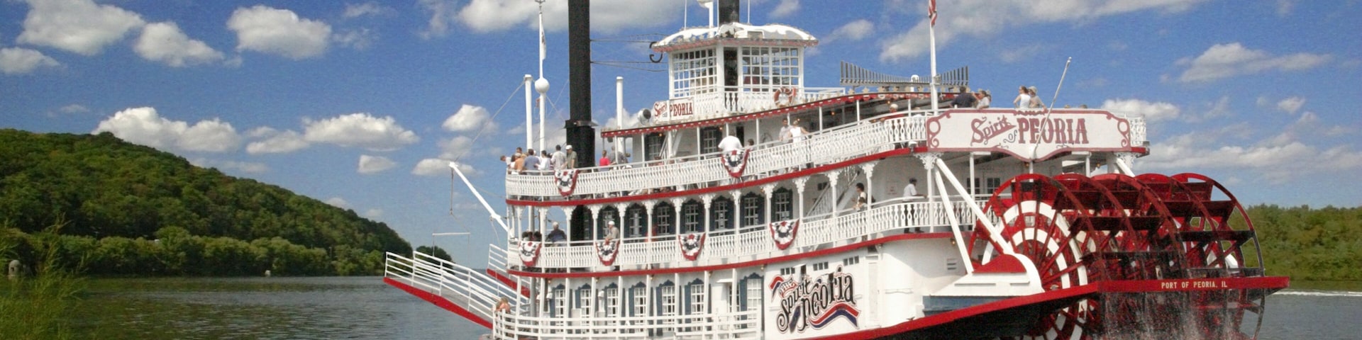 A steamboat named Spirit of Peoria traveling on a river.