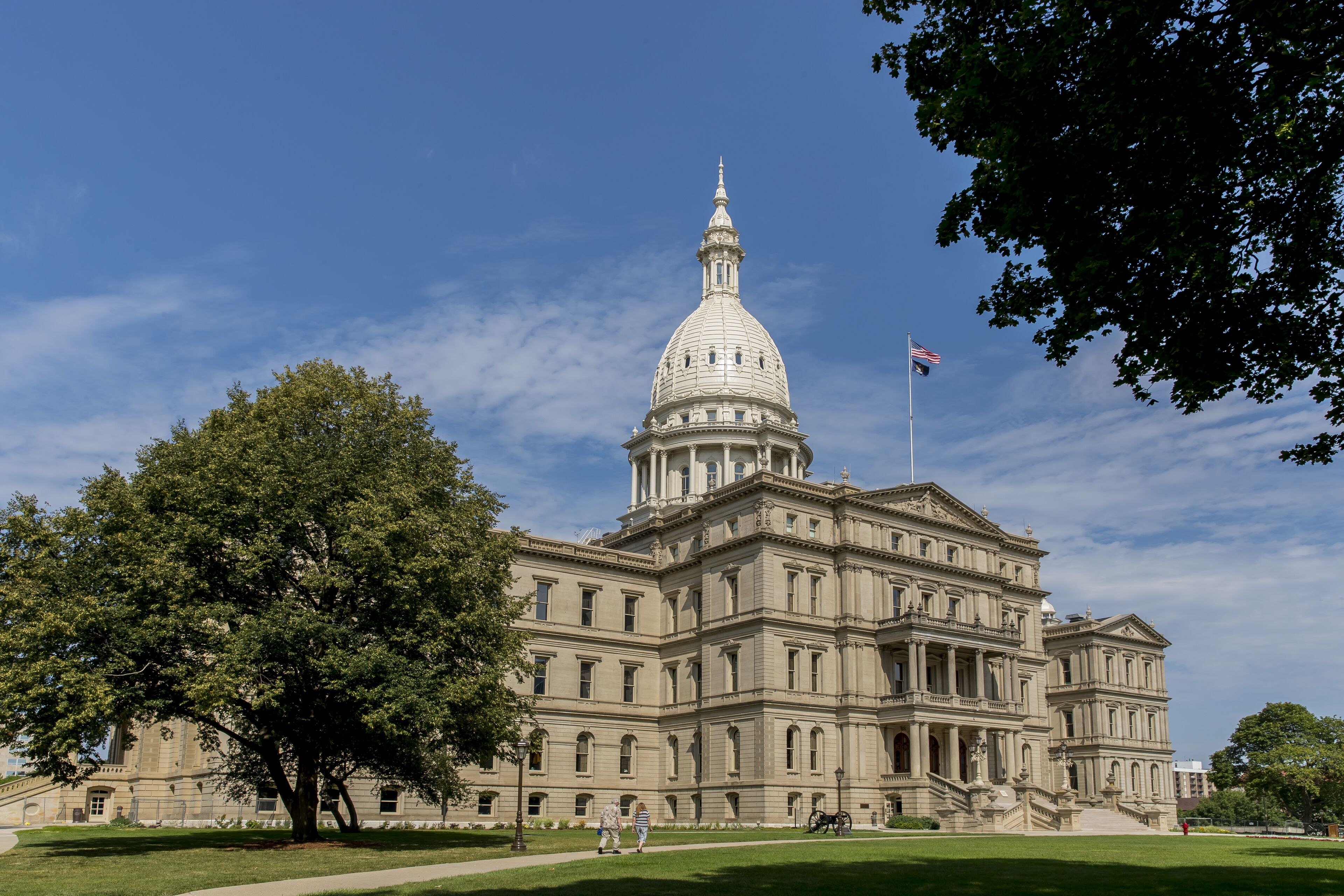 A large, historic building with a prominent dome and flag.