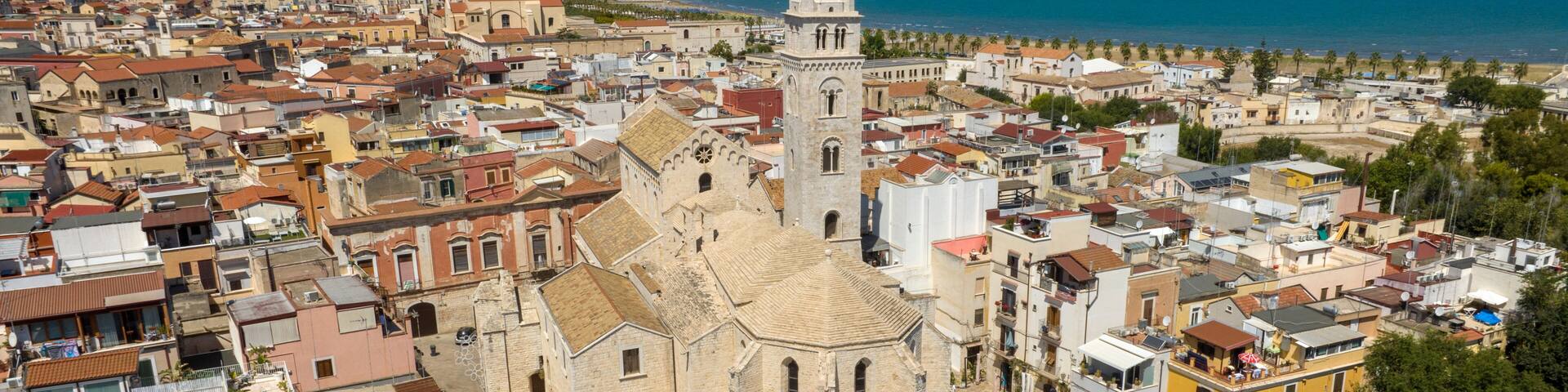Aerial view of the Basilica of Santa Maria Maggiore in the historic center of Barletta, Puglia, Italy. It is the cathedral and it was built in Romanesque style. In background is the Adriatic sea.