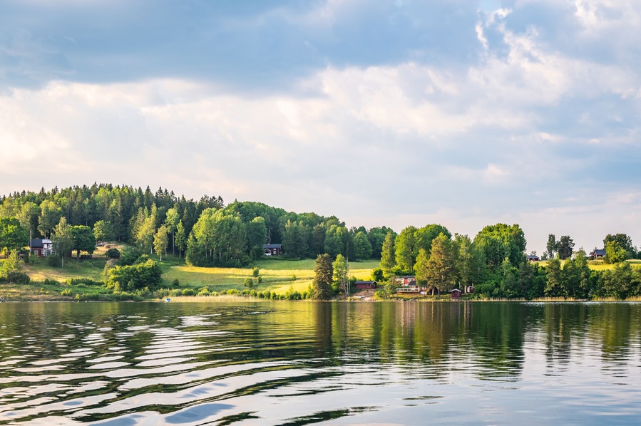 Swedish Summer Landscape with Lake and Countryside Houses.