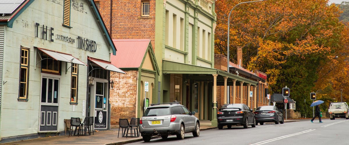 A street lined with historic buildings, including a pub named 'The 11th Floor Tinshed'.