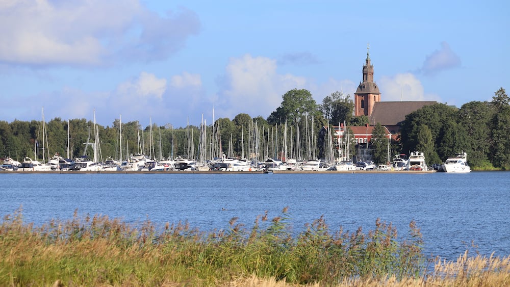 View across the picturesque Lake Vattern, towards Askersund church and marina in Orebro County in Sweden. Sunny summers day, with blue sky. Copy space.