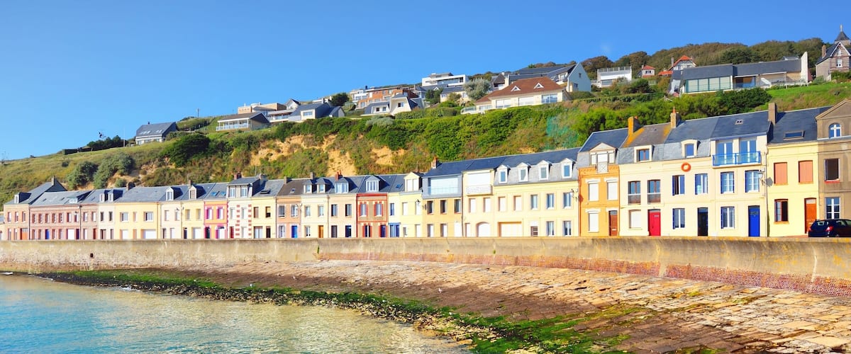 Promenade near colorful houses, white cliffs and English Channel on a clear day. Fécamp, Normandy, France. Blue sky, azure water. Nature, history, past, landmark, sightseeing, travel. Panoramic view
