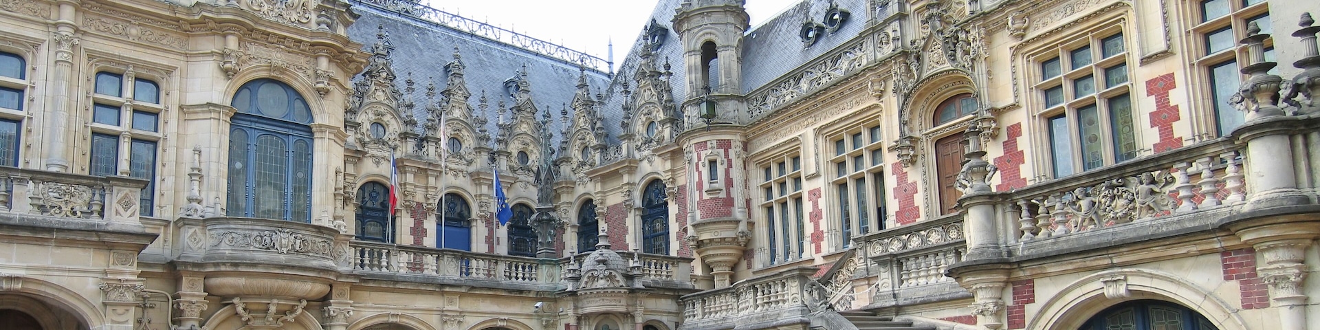 A historic building with ornate architecture, including a central staircase and multiple statues.