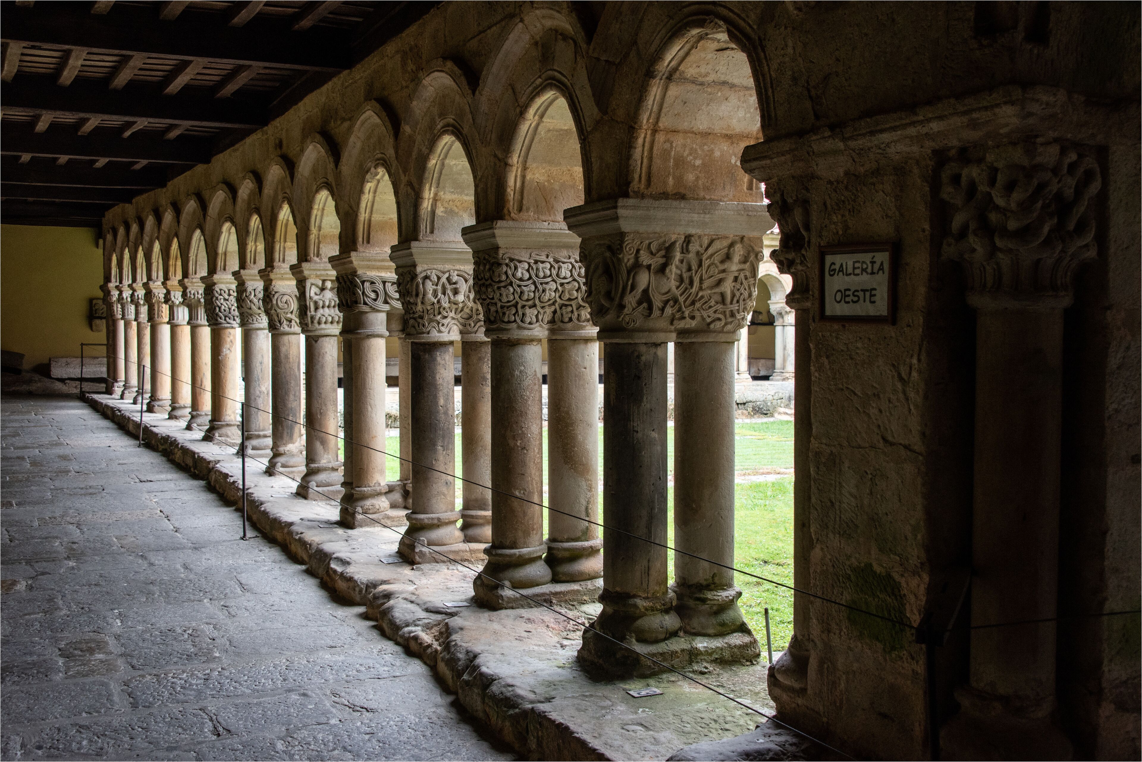 A series of stone columns with intricate carvings, leading to a covered walkway.