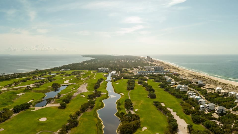 A coastal golf course with a beach and ocean.
