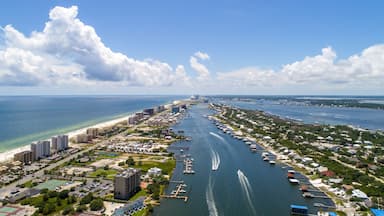 An aerial view of a coastal city with a marina, buildings, and a beach.