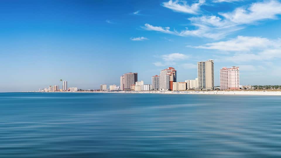 A coastal cityscape with high-rise buildings and a beach.