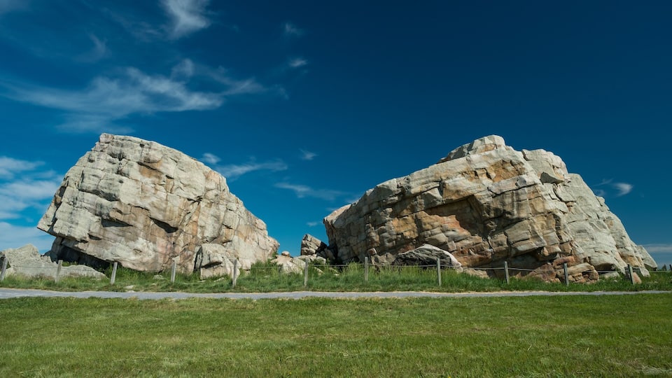 A large rock formation with a clear blue sky in the background.