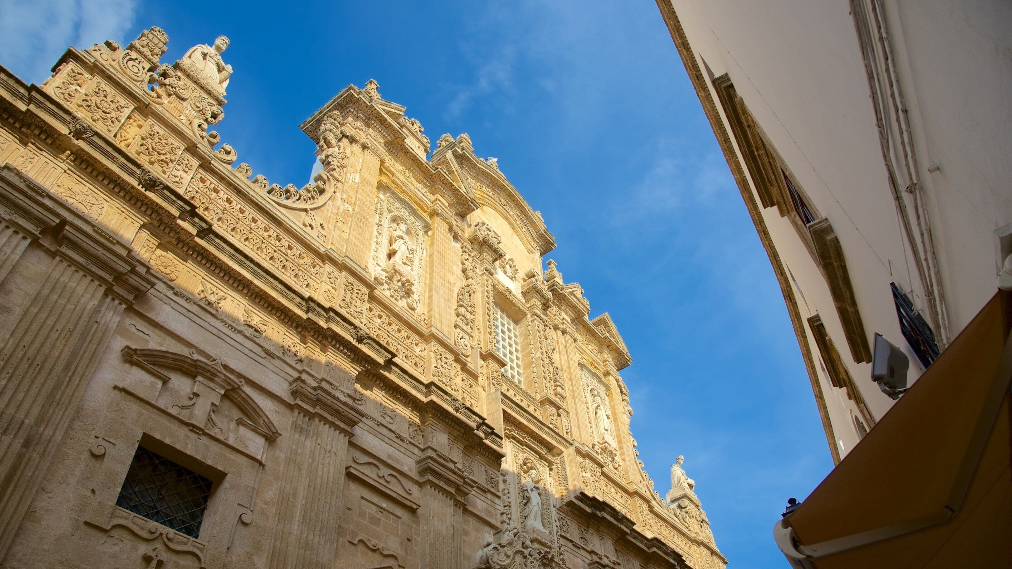 A detailed facade of a historic building with ornate carvings and statues.