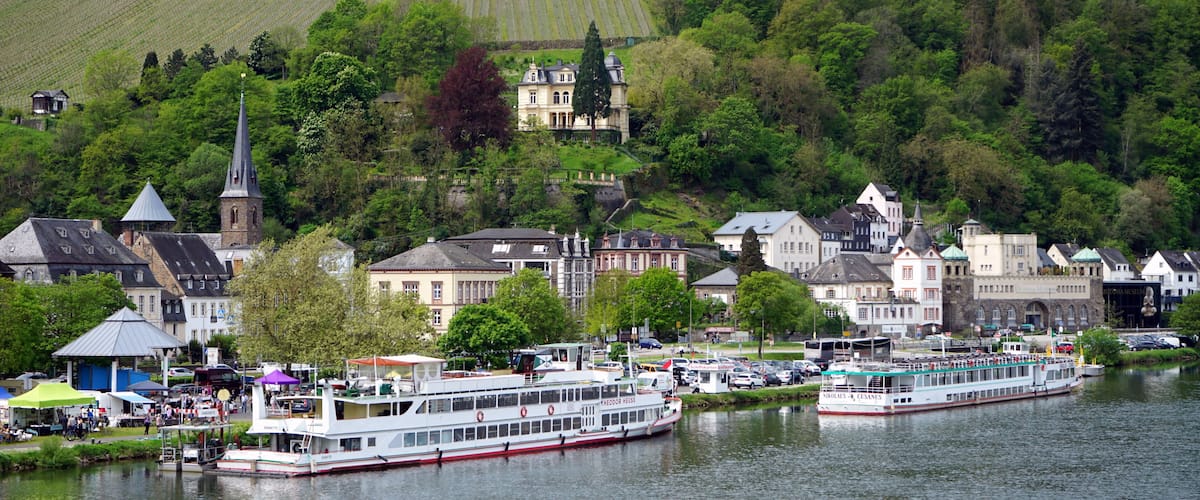 Ausflugsschiffe im Frühling bei Sonnenschein am Ufer der Mosel mit der Villa Sonora im Hintergrund in Traben-Trarbach im Kreis Bernkastel-Wittlich in Rheinland-Pfalz in Deutschland