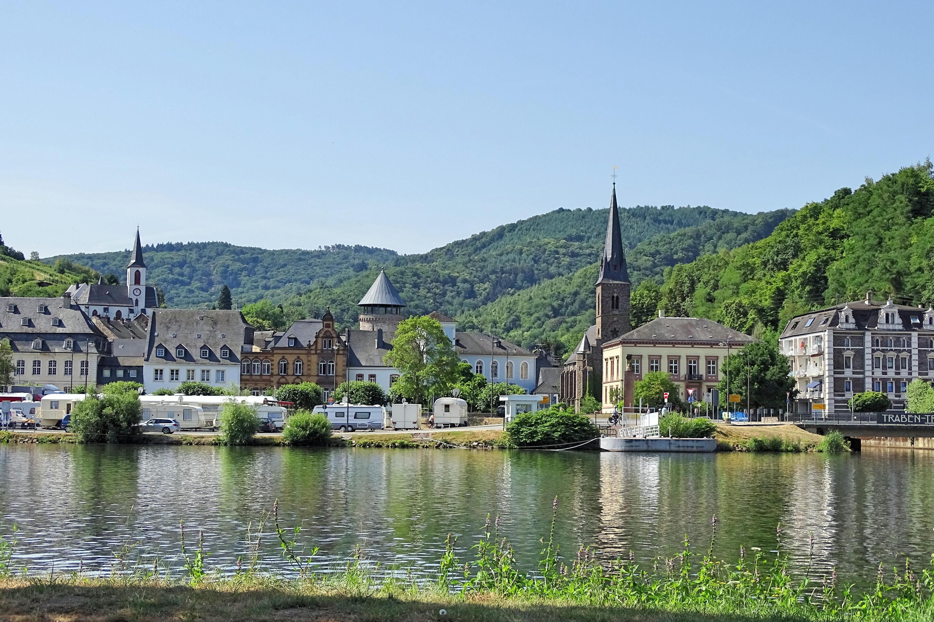 A lakeside town with historic buildings, a church, and a boat dock.
