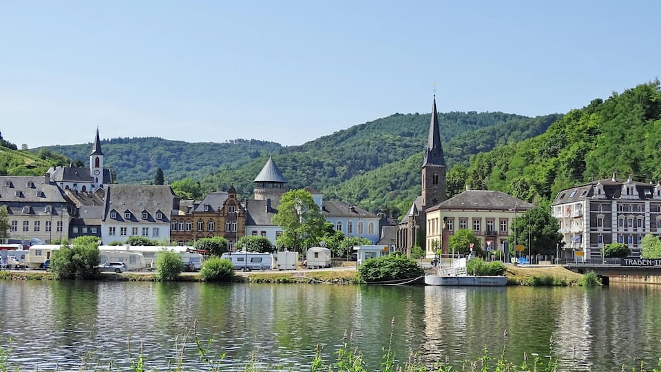 A lakeside town with historic buildings, a church, and a boat dock.