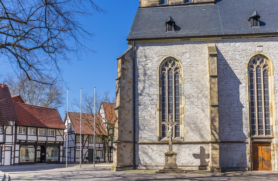 A stone church with arched windows and a crucifix.