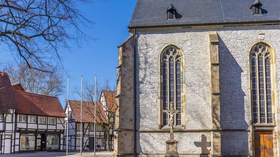 A stone church with arched windows and a crucifix.