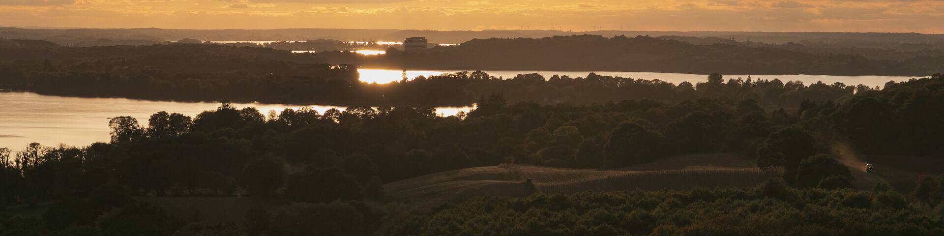 Magnificent panoramic view to the Dieksee and hilly farmland in warm evening light.
