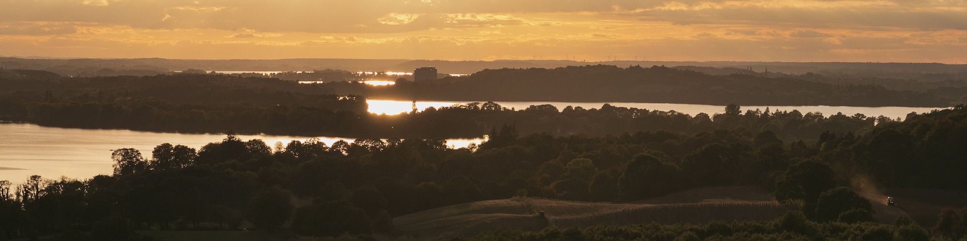 Magnificent panoramic view to the Dieksee and hilly farmland in warm evening light.
