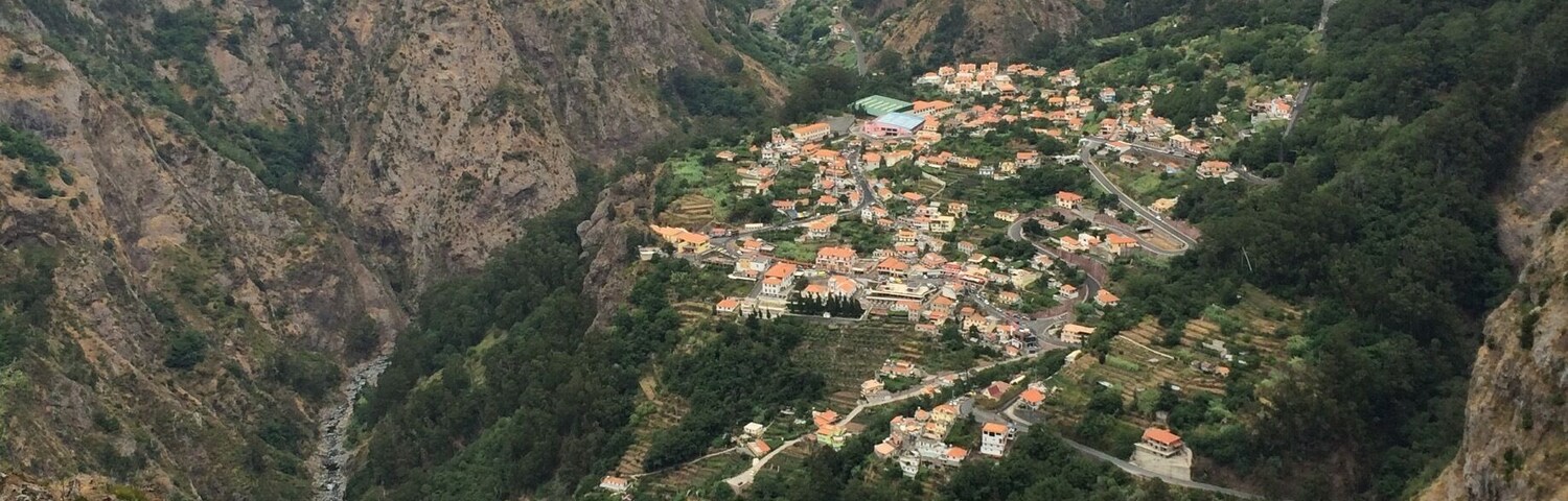 Un valle con un pueblo pequeño situado entre montañas escarpadas.