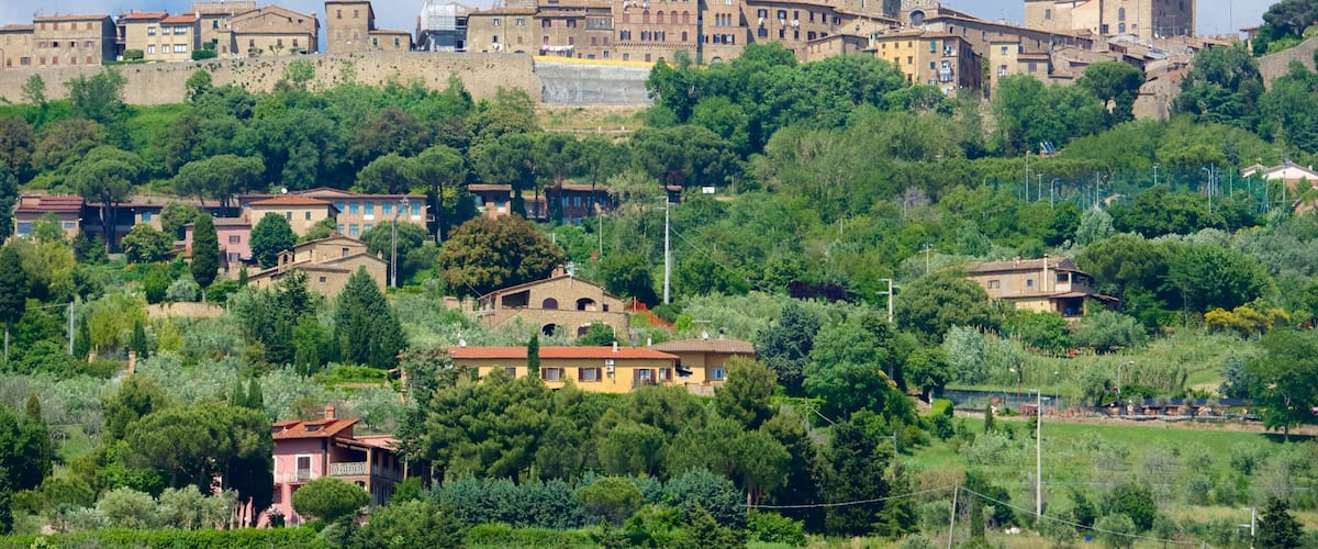 A historic town with medieval architecture, including a prominent tower and a church with a dome.