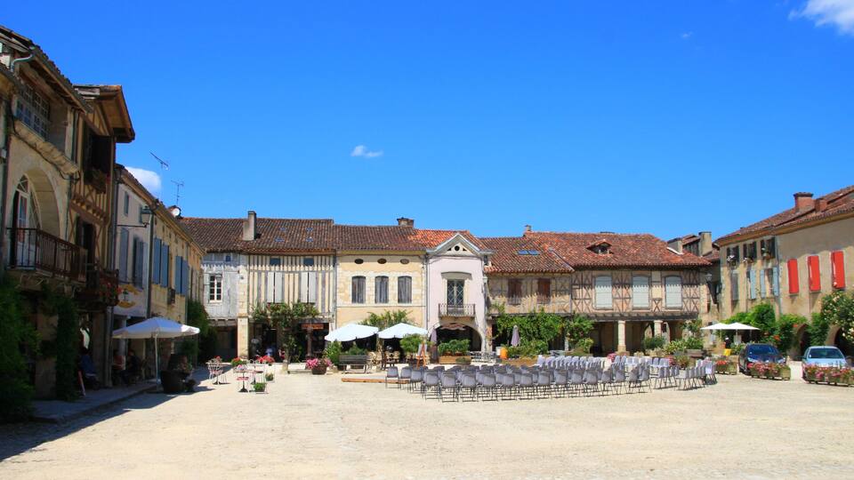 A cobblestone square with outdoor seating and historic buildings.