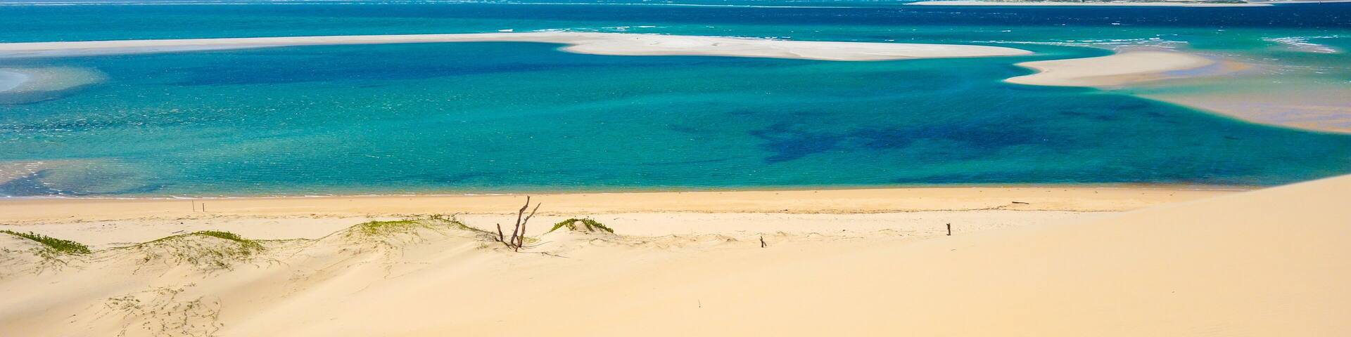 Une plage aux eaux turquoise et limpides et au sable blanc.