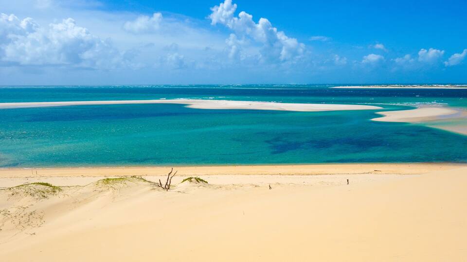 A beach with clear turquoise waters and white sand.