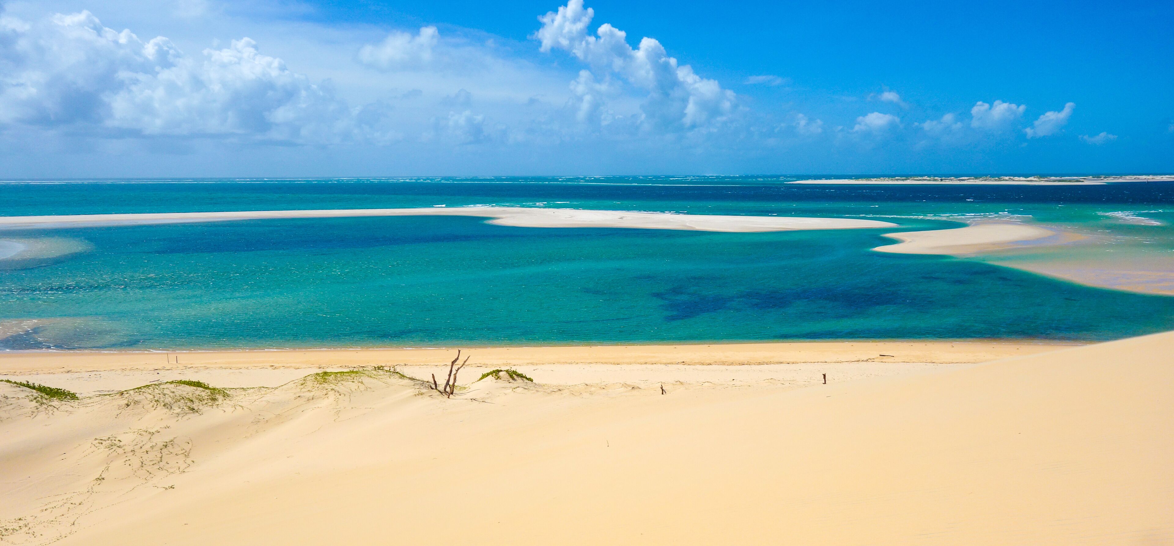 A beach with clear turquoise waters and white sand.