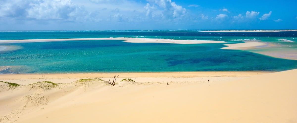 A beach with clear turquoise waters and white sand.