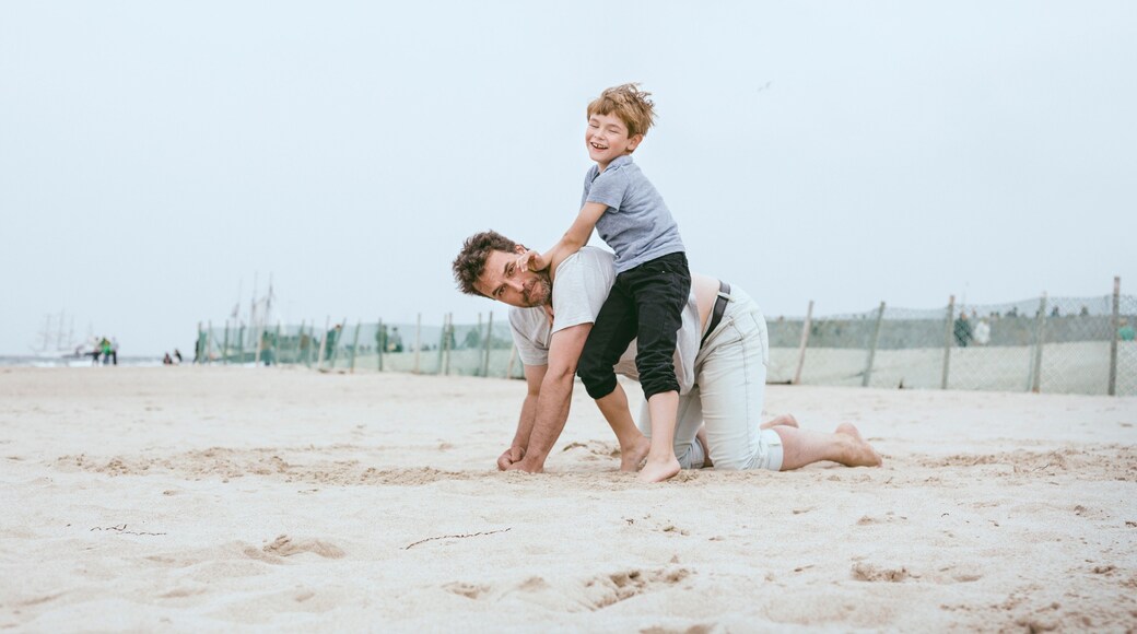 Father and little son playing together on the beach