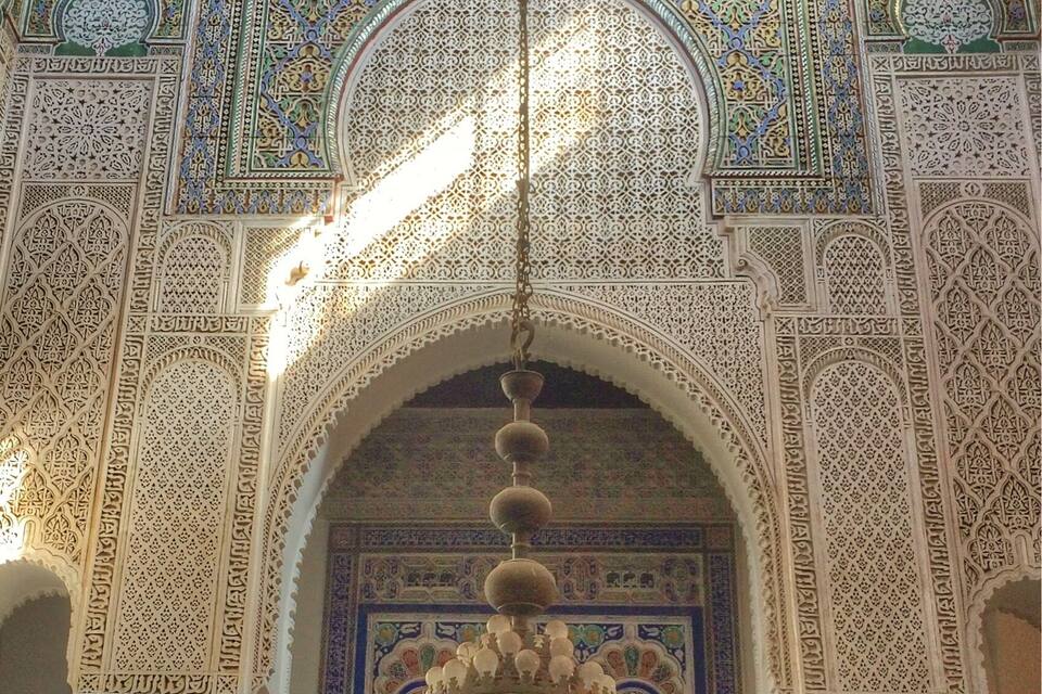An ornate interior with intricate tile work and a large chandelier.