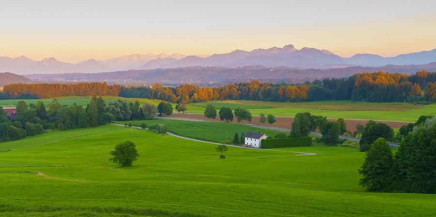 Wide panoramic view of the bavarian alps in germany with beautiful light during a summer sunset, as seen from Feldkirchen-Westerham, Bavaria.