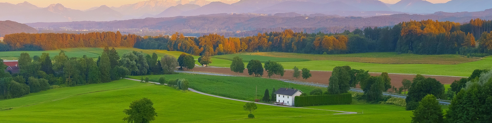 Wide panoramic view of the bavarian alps in germany with beautiful light during a summer sunset, as seen from Feldkirchen-Westerham, Bavaria.