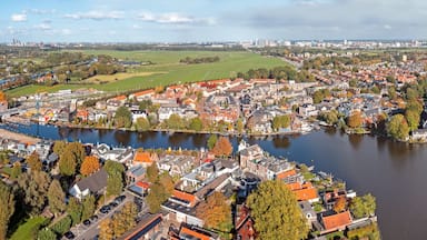 Vista aérea de un pueblo con un río, rodeado de vegetación y edificios.